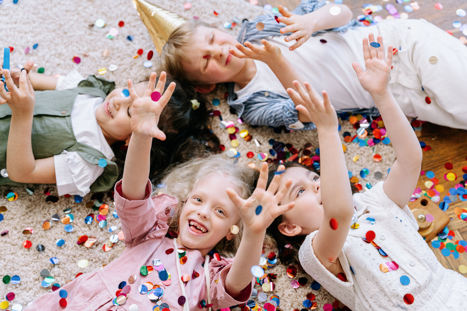  Children Lying on a Floor while in a Birthday Party